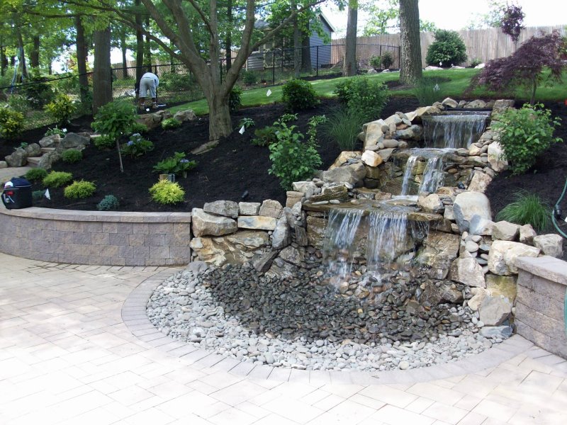 backyard moss rock waterfall with retaining walls